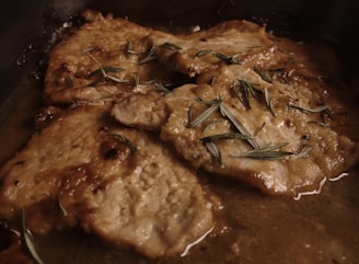 Elegant serving of roasted beef slices garnished with rosemary and garlic.