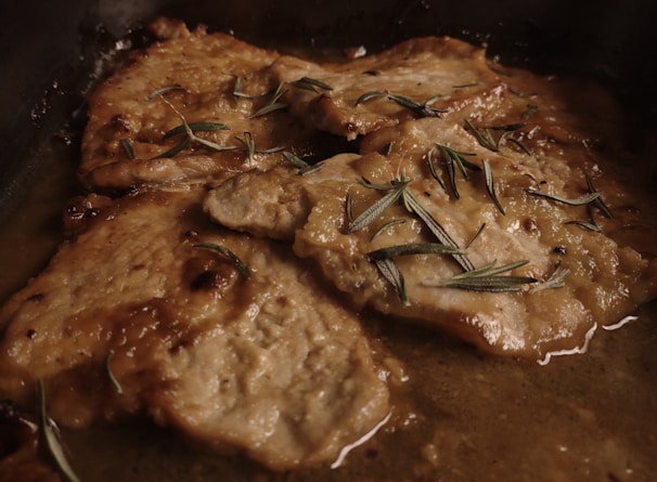 Elegant serving of roasted beef slices garnished with rosemary and garlic.