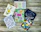 A set of beautifully painted handmade cards spread out on a wooden table.