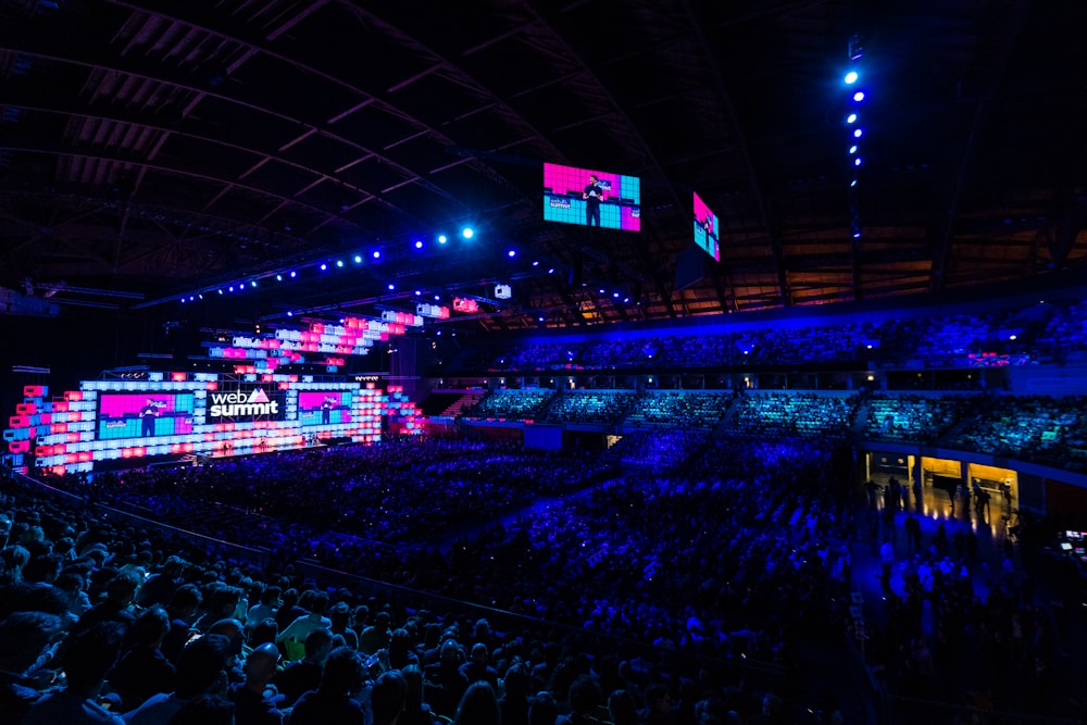 a large crowd of people in a dark arena
