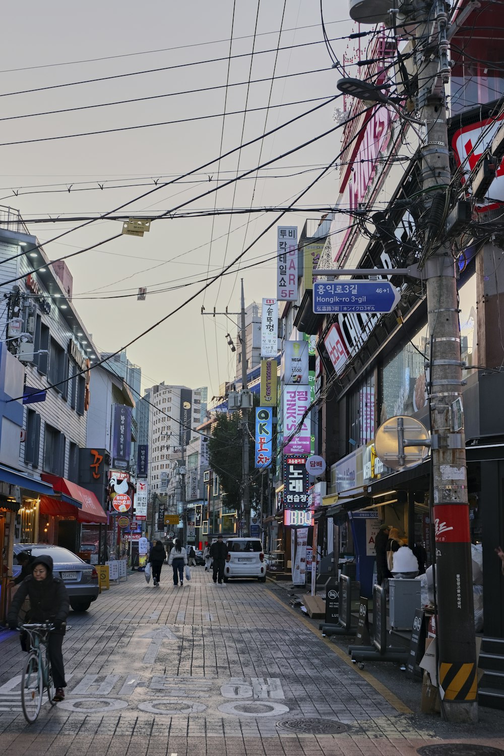 a city street lined with tall buildings and lots of wires