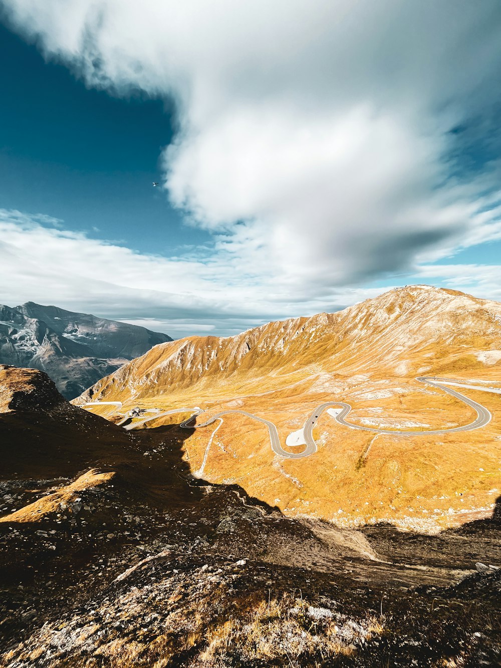 a scenic view of a winding road in the mountains