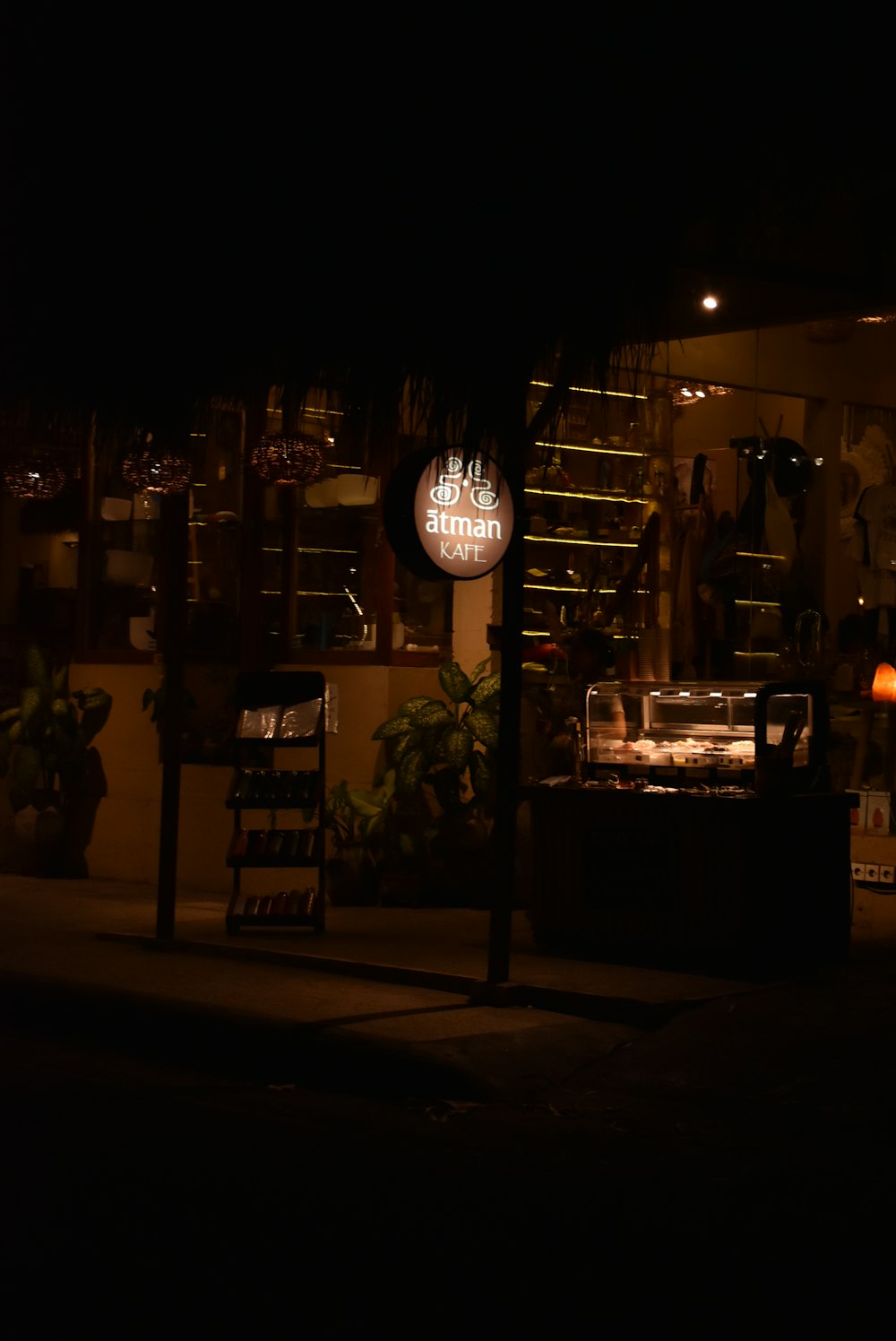 a dark street at night with a store sign lit up