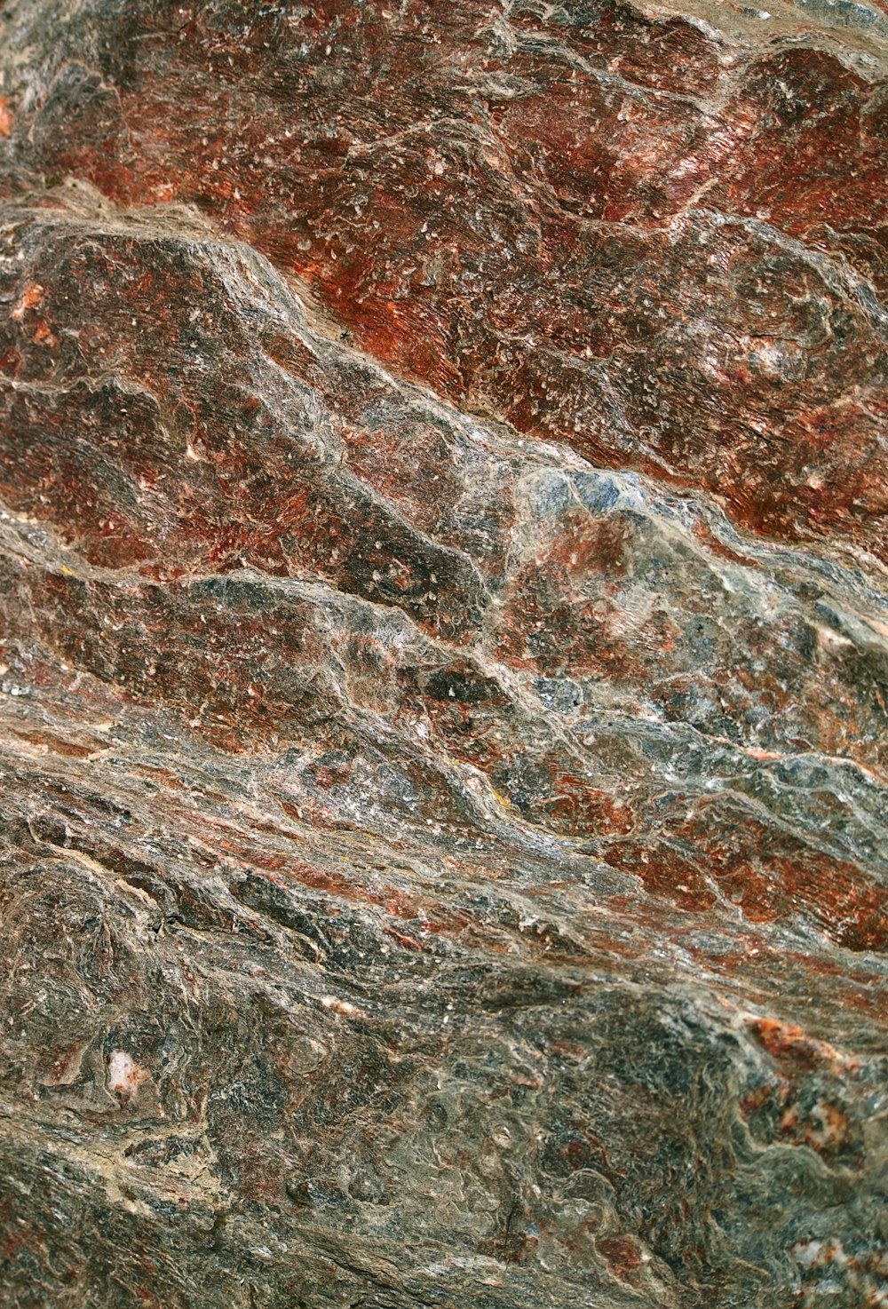 a close up of a marble surface with red and green colors