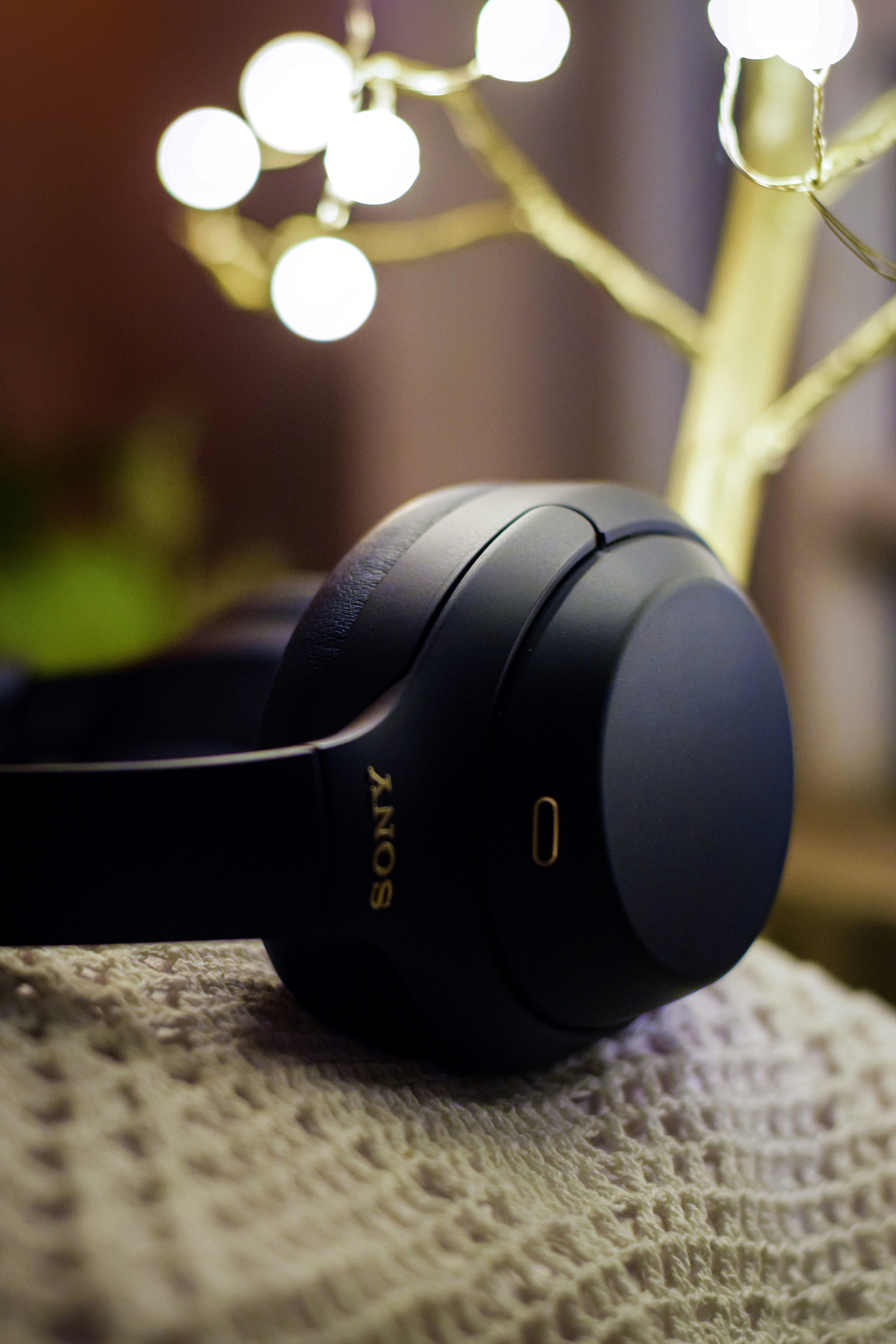 Black Sony headphones on dark surface, moody product shot