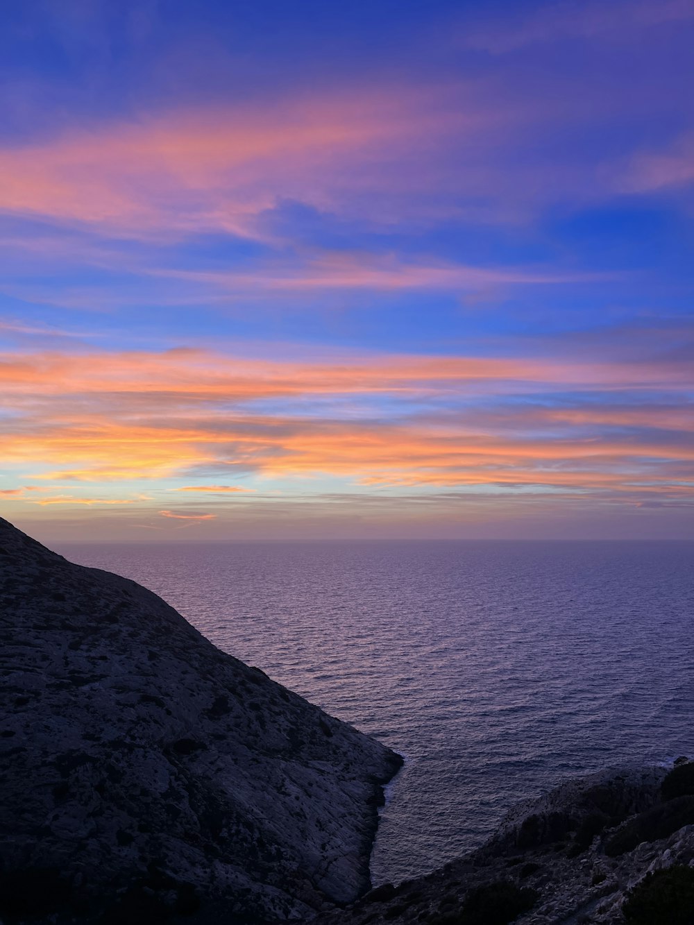 a person standing on top of a hill next to the ocean