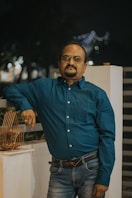 a man standing next to a bird cage