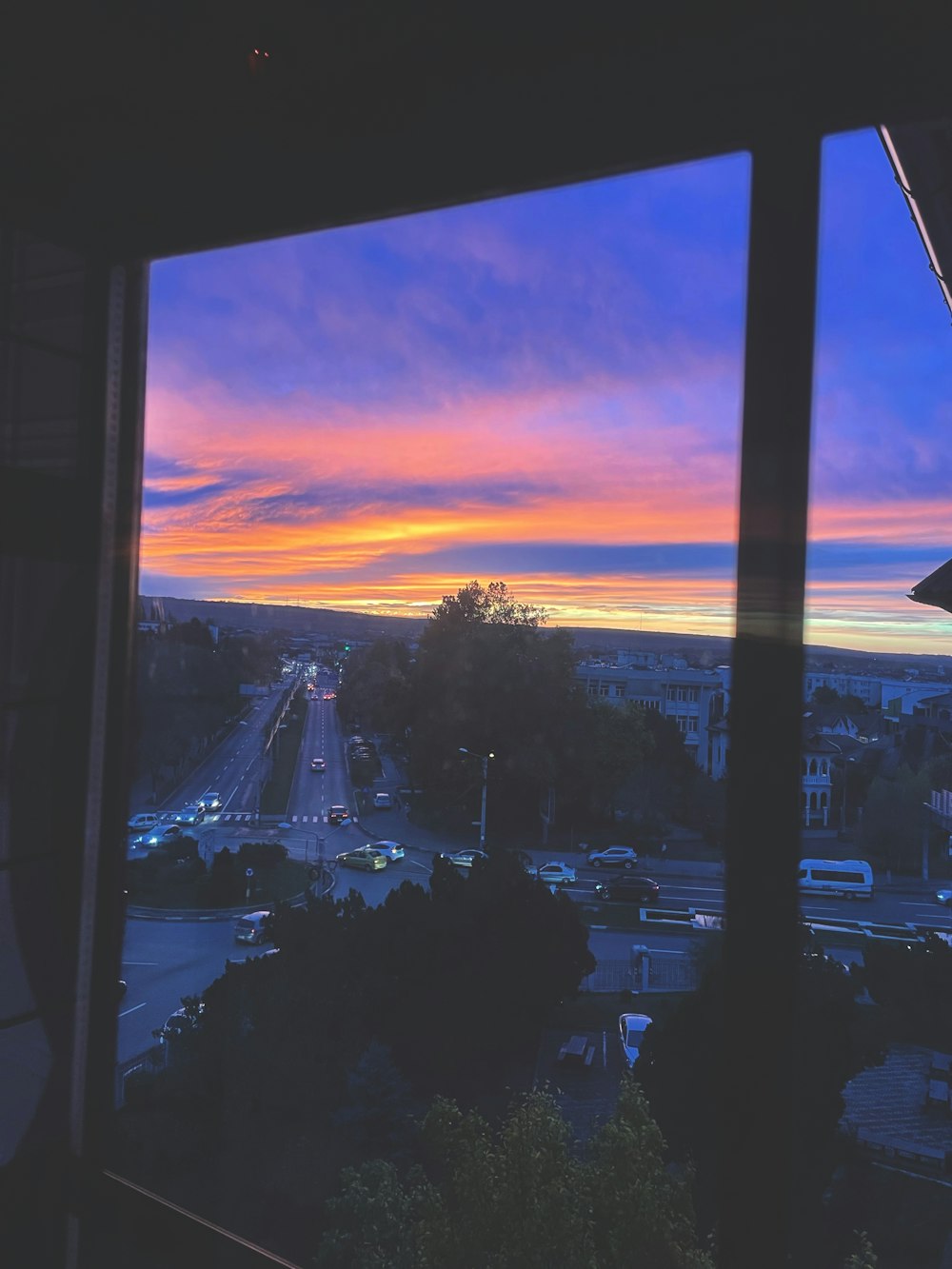 a view of a city from a window at sunset