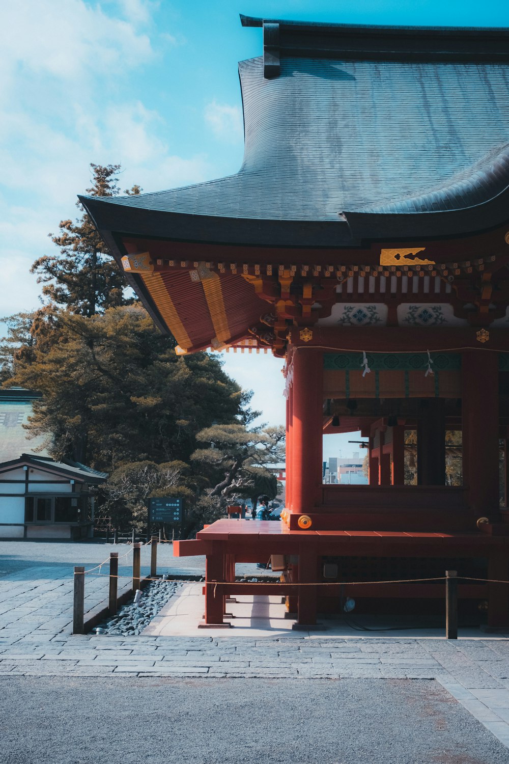 a red pagoda with a bench in front of it