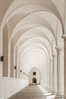 An elegant hallway showcasing a row of minimalist wall sconces highlighting architectural details.