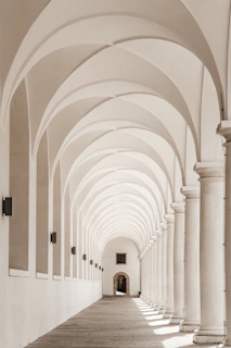 An elegant hallway showcasing a row of minimalist wall sconces highlighting architectural details.