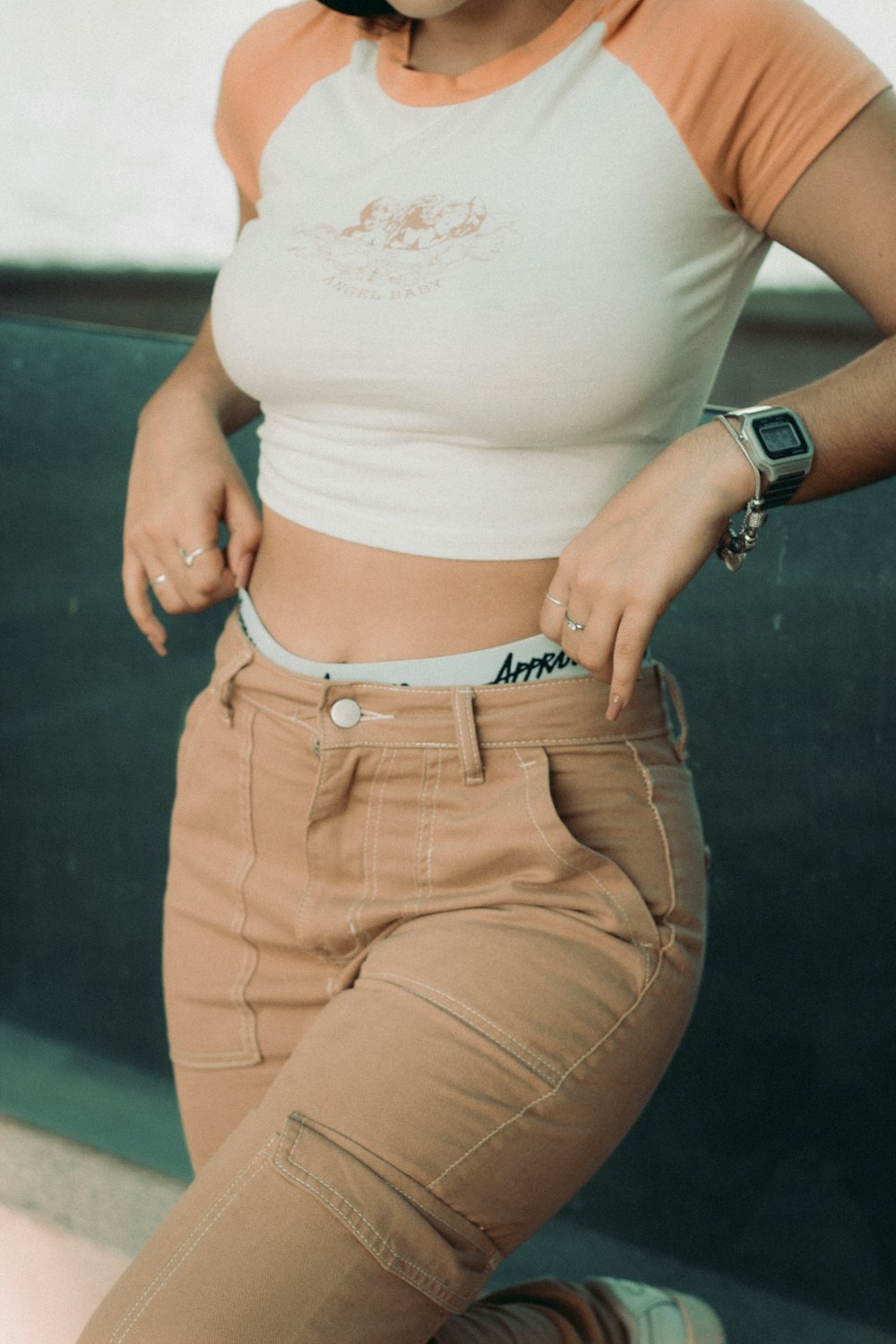 a woman in a white shirt and tan pants