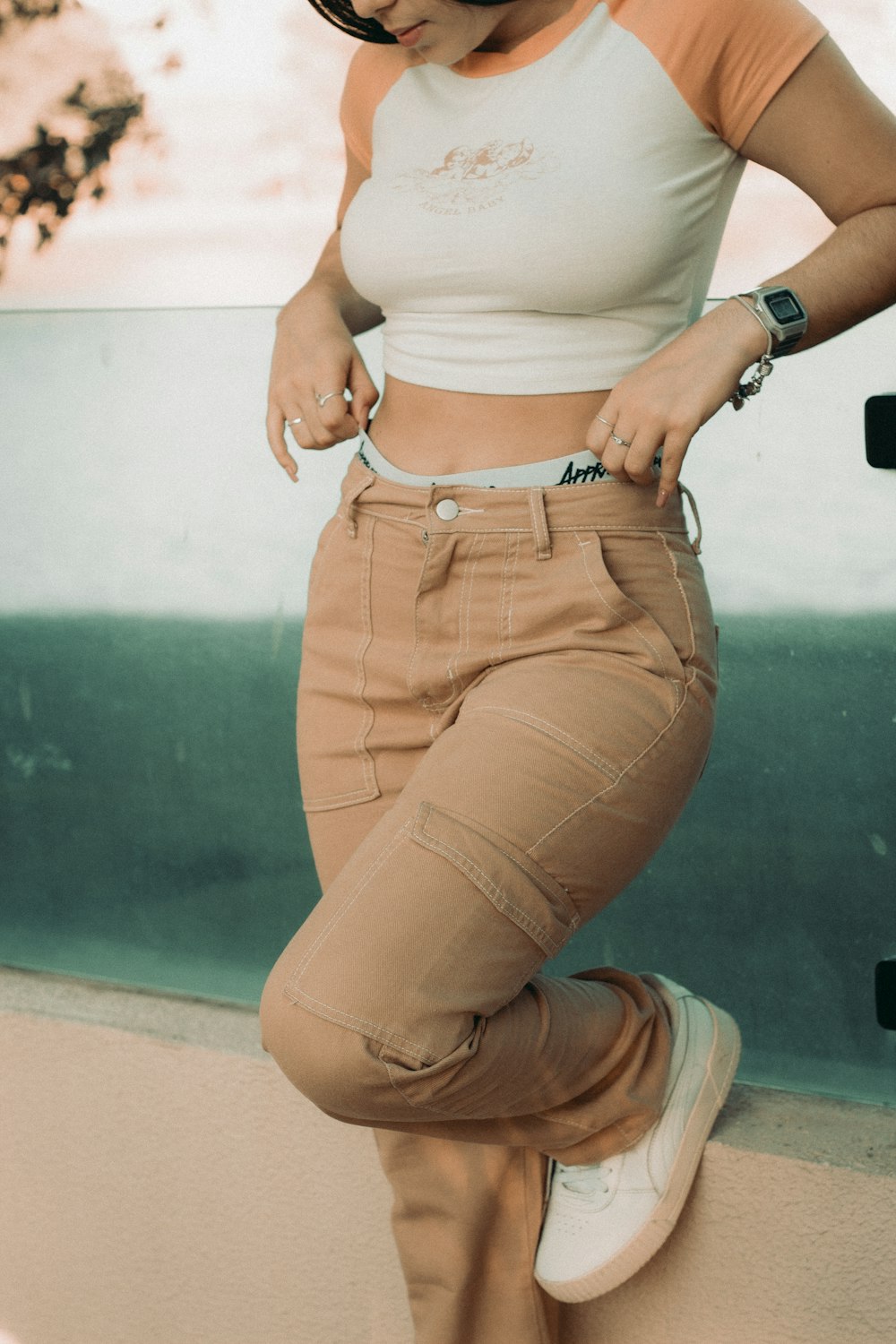 a woman standing on a ledge with her hands on her hips