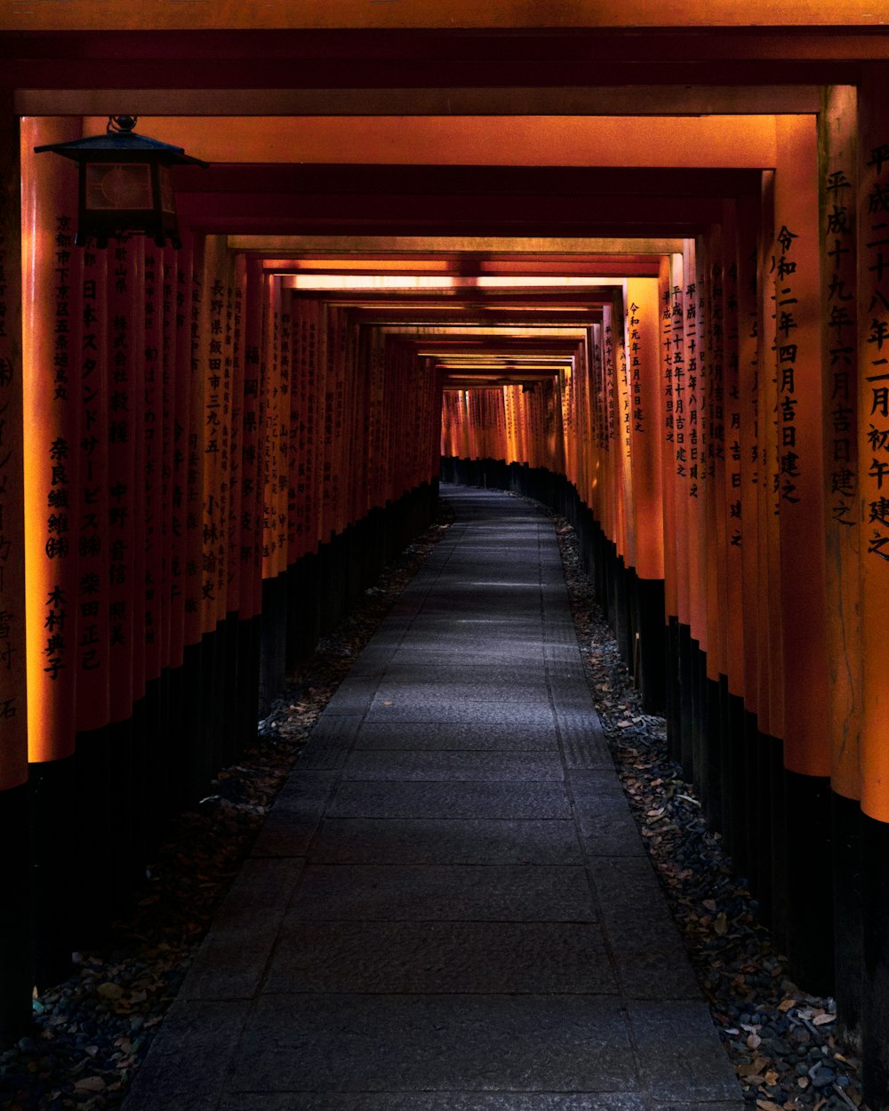 a tunnel of red and orange lanterns with asian writing on them