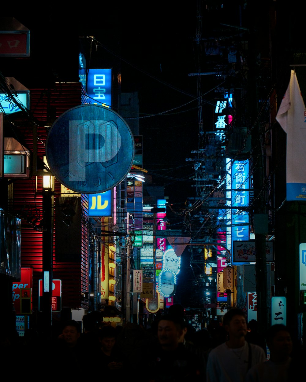 a city street at night with neon signs