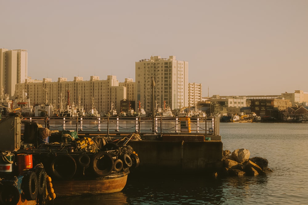 a boat docked in a harbor with a city in the background