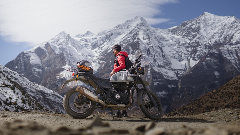 a person sitting on a motorcycle on a mountain
