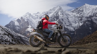 a man riding a motorcycle on top of a mountain