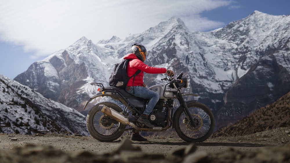 a man riding a motorcycle on top of a mountain