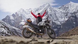 a person standing next to a motorcycle on a dirt road