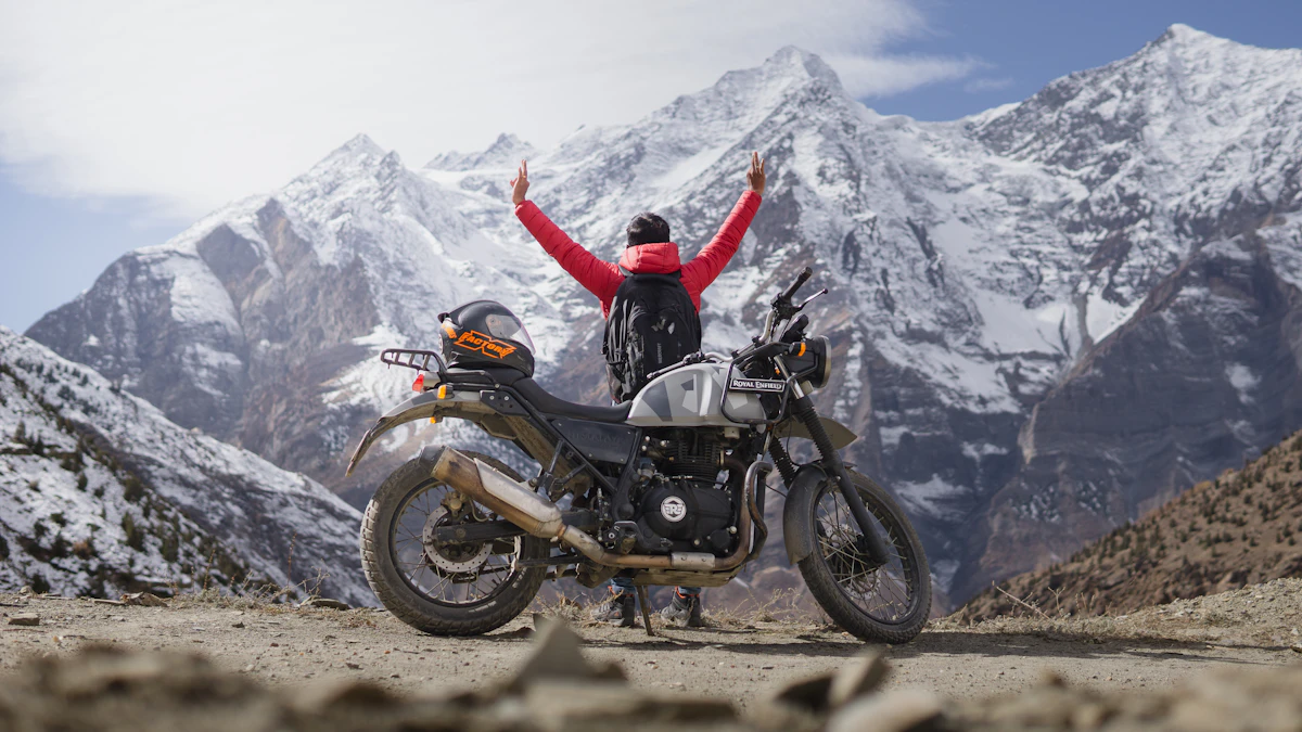 Rider standing beside a motorcycle on a remote dirt road high in the Nepali Himalayas