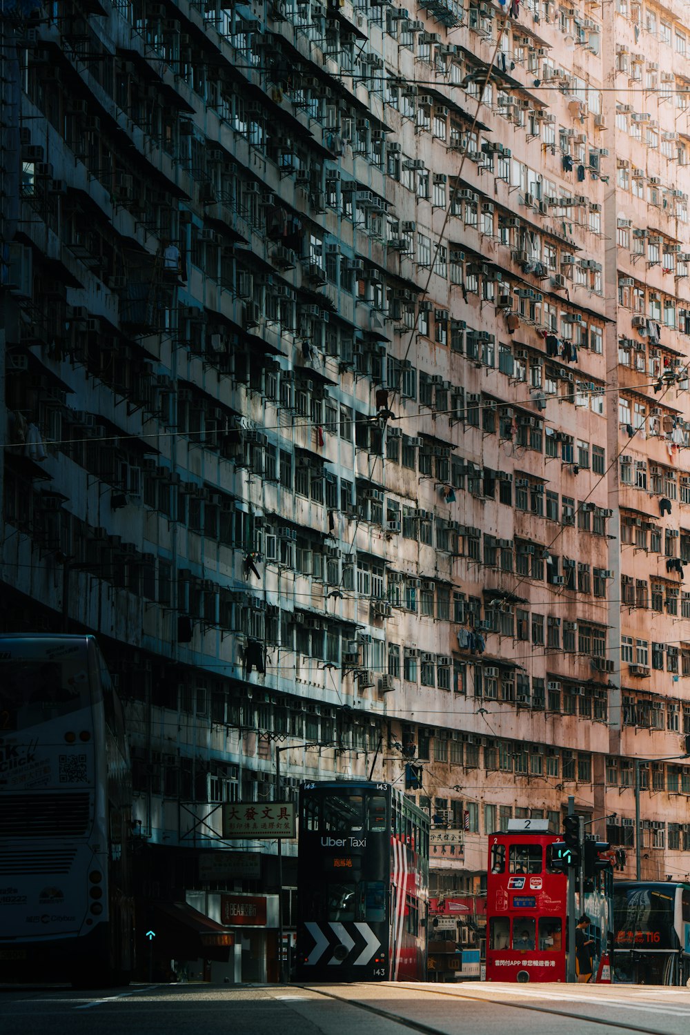 a red double decker bus parked in front of a tall building