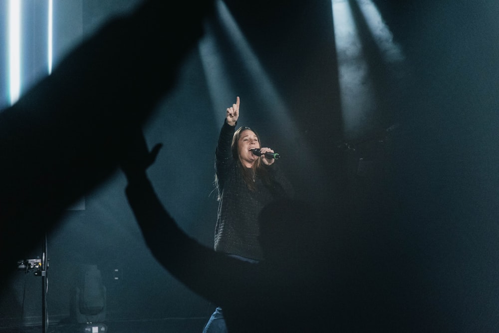 a woman standing on top of a stage holding a microphone