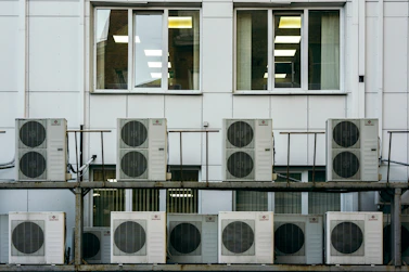 Technicians installing a large air handling unit inside a commercial building.