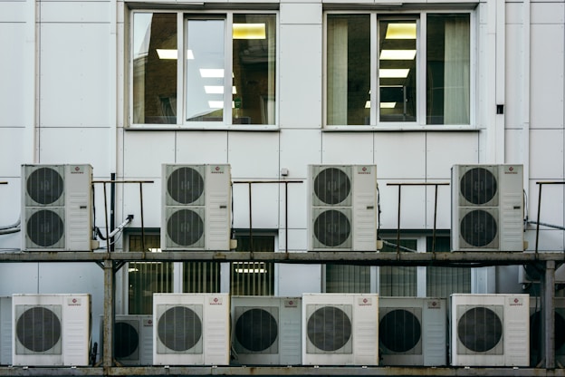 A technician performing HVAC maintenance on a residential unit.