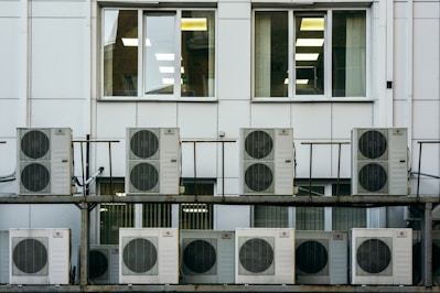a row of air conditioners sitting in front of a building