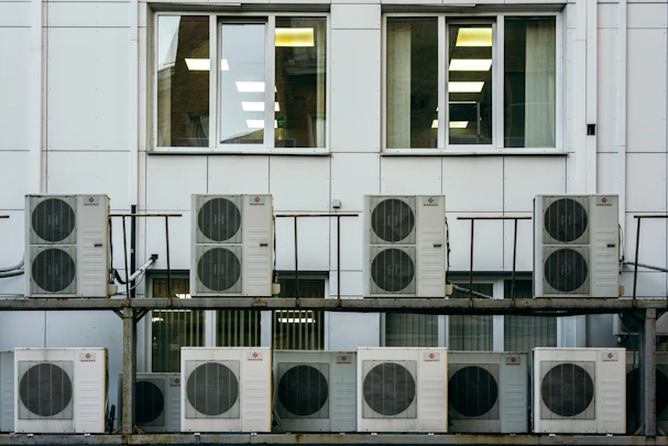 Technician installing a modern air conditioning unit in a commercial building.