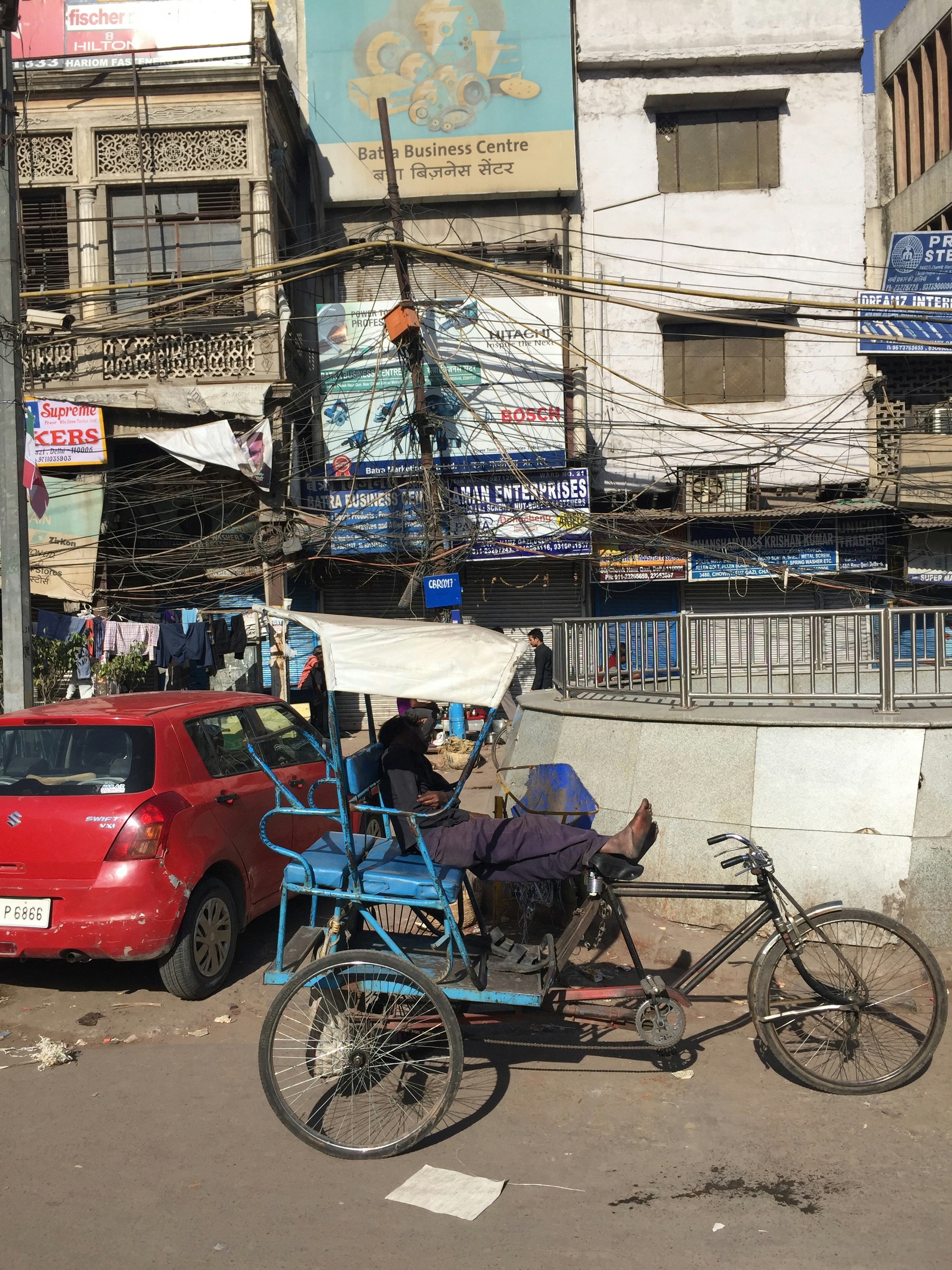 a man riding a bike with a cart attached to it