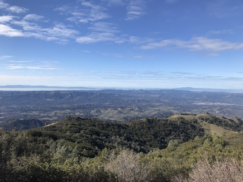 uma vista de um vale e montanhas do topo de uma colina