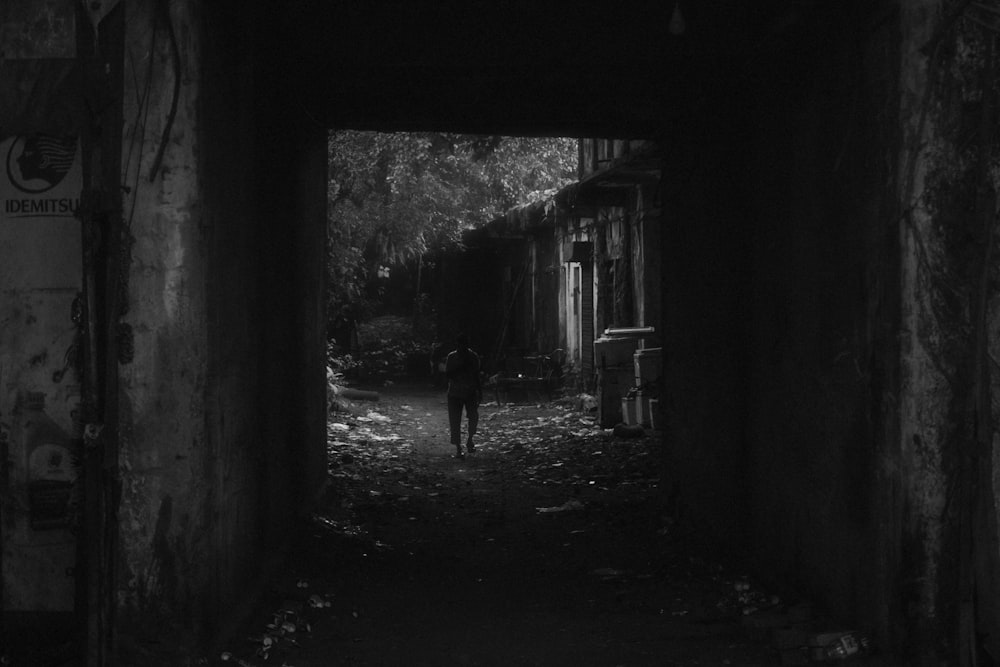 a person walking down a dark alley way