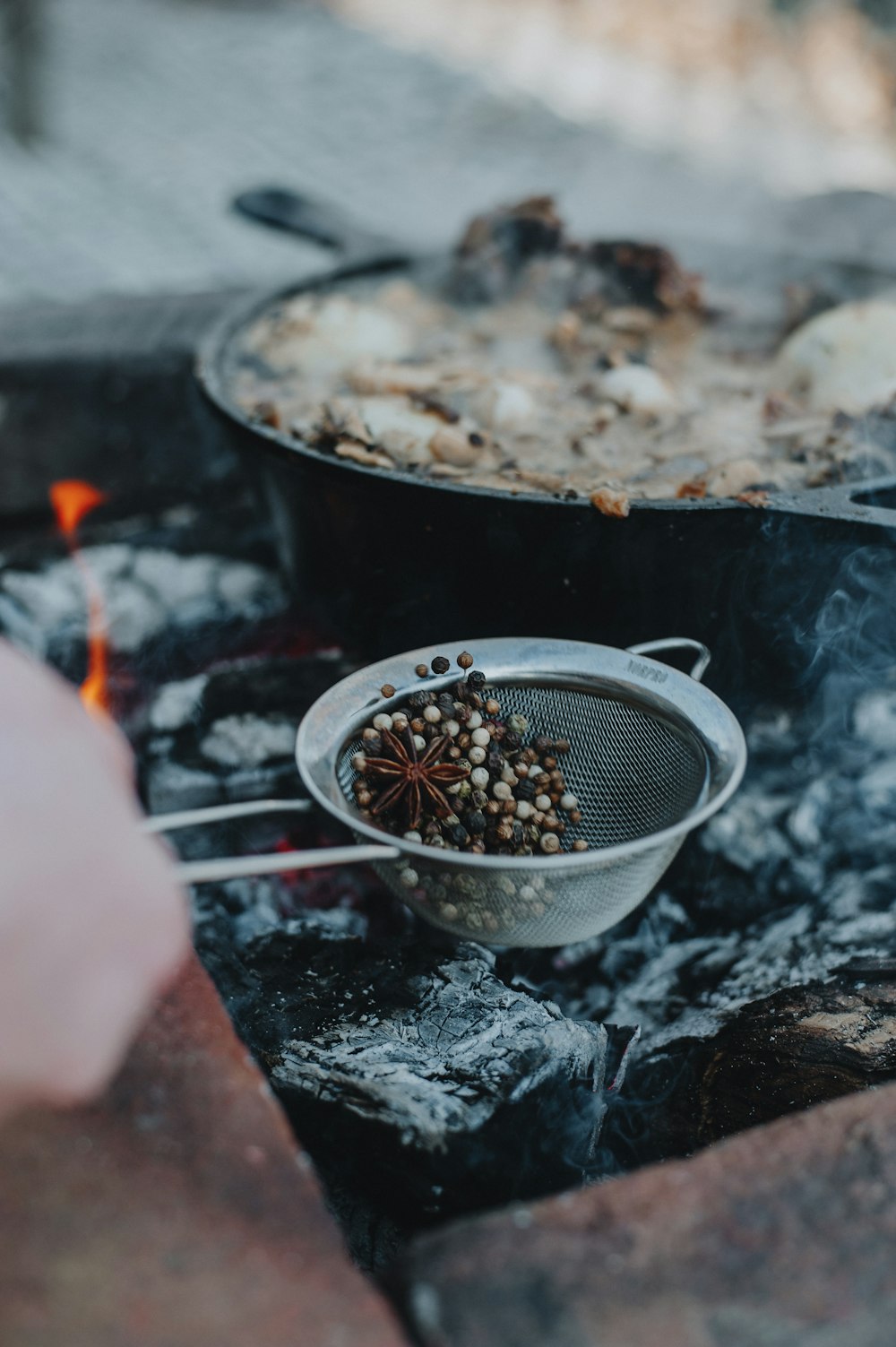 a person cooking food on a grill over a fire