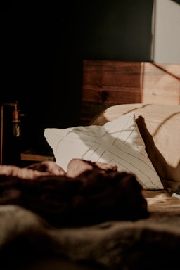 A peaceful bedroom scene with soft lighting and a comfortable bed.