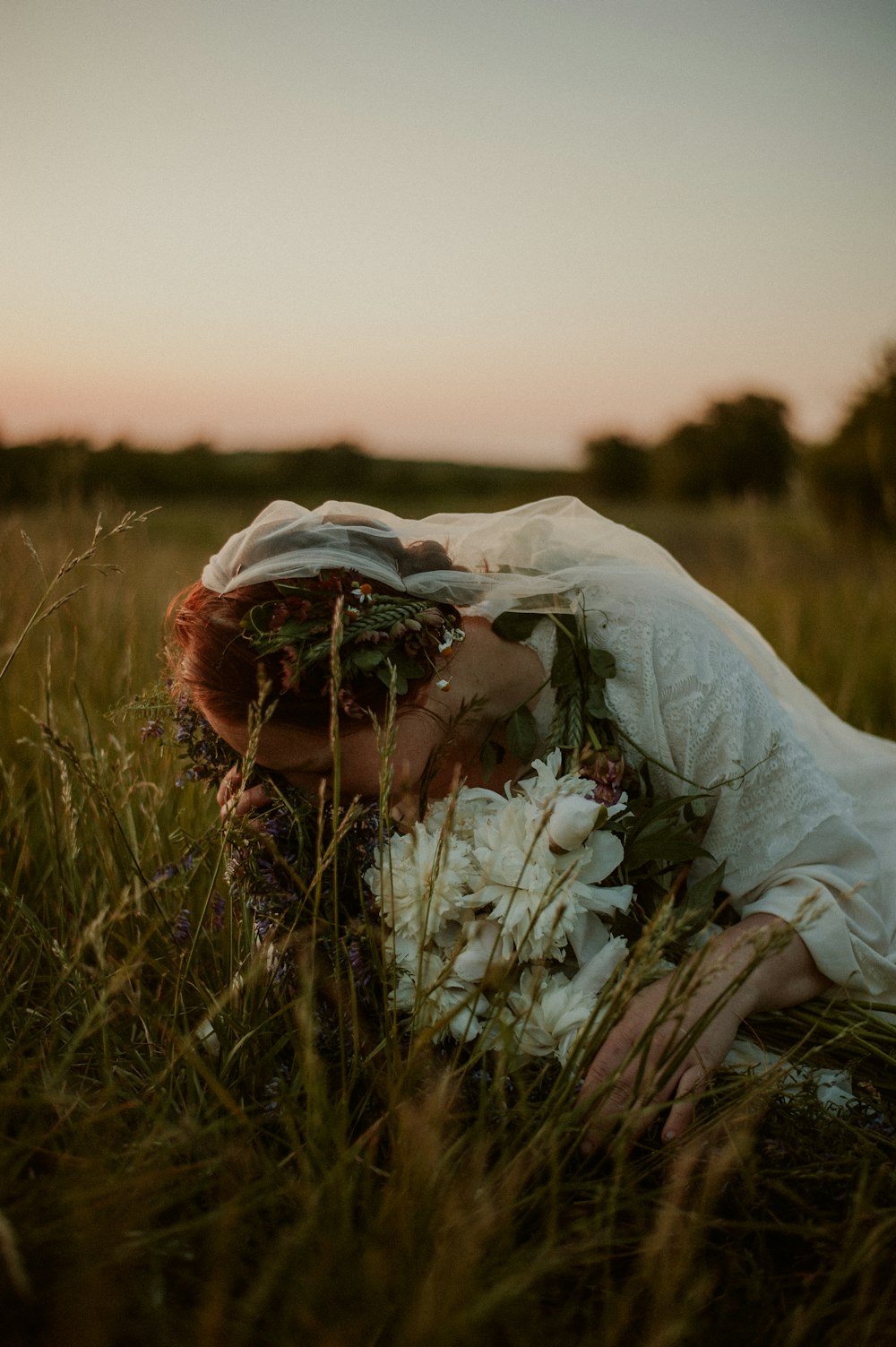 a bride and groom kissing in a field