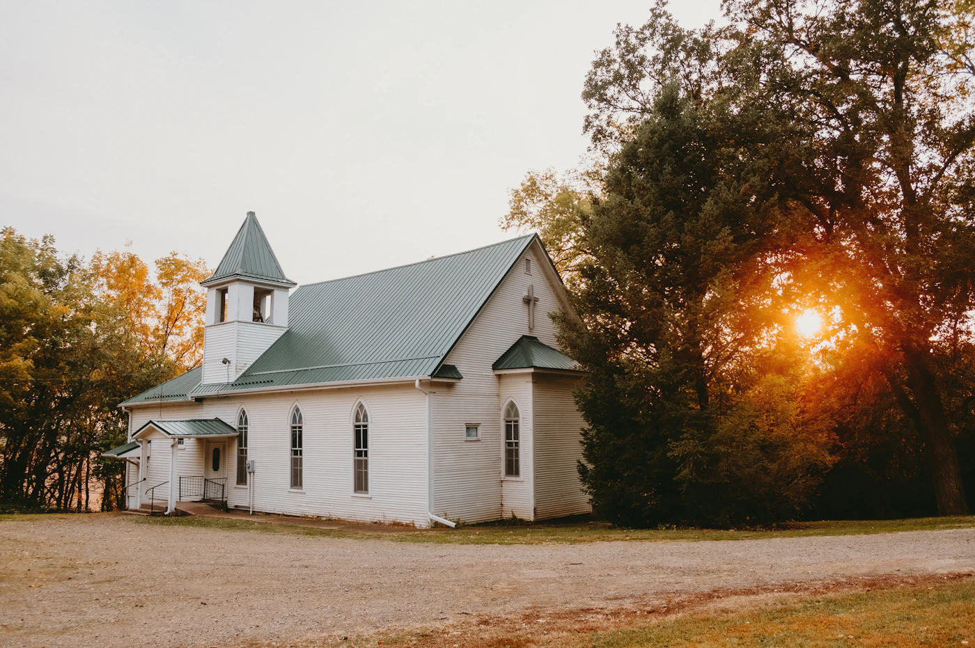 A white country church with a steeple at golden hour
