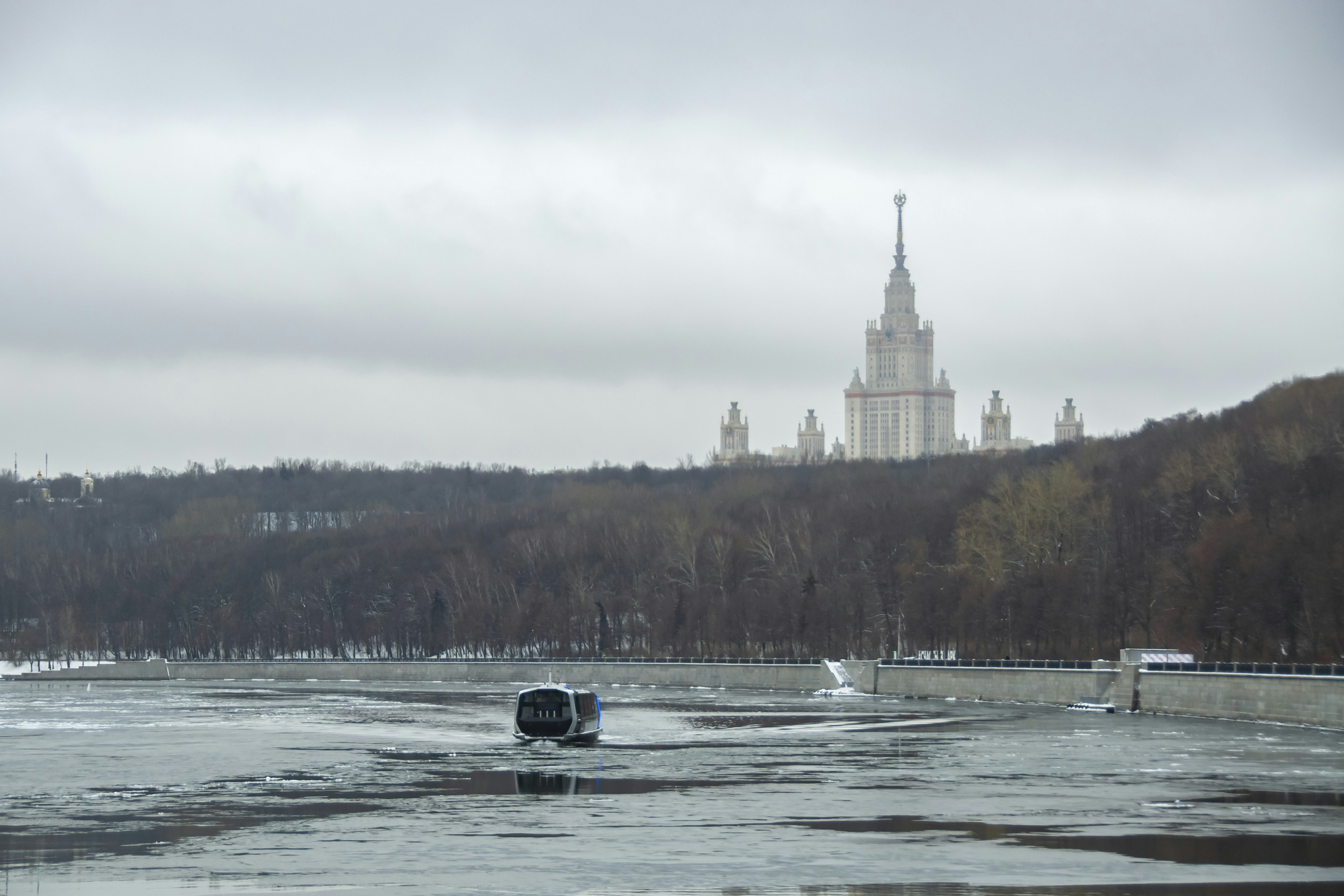 a boat on a frozen river with a large building in the background