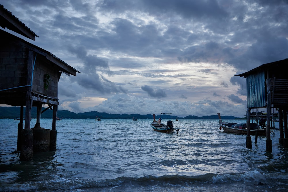 um par de barcos flutuando em cima de um corpo de água