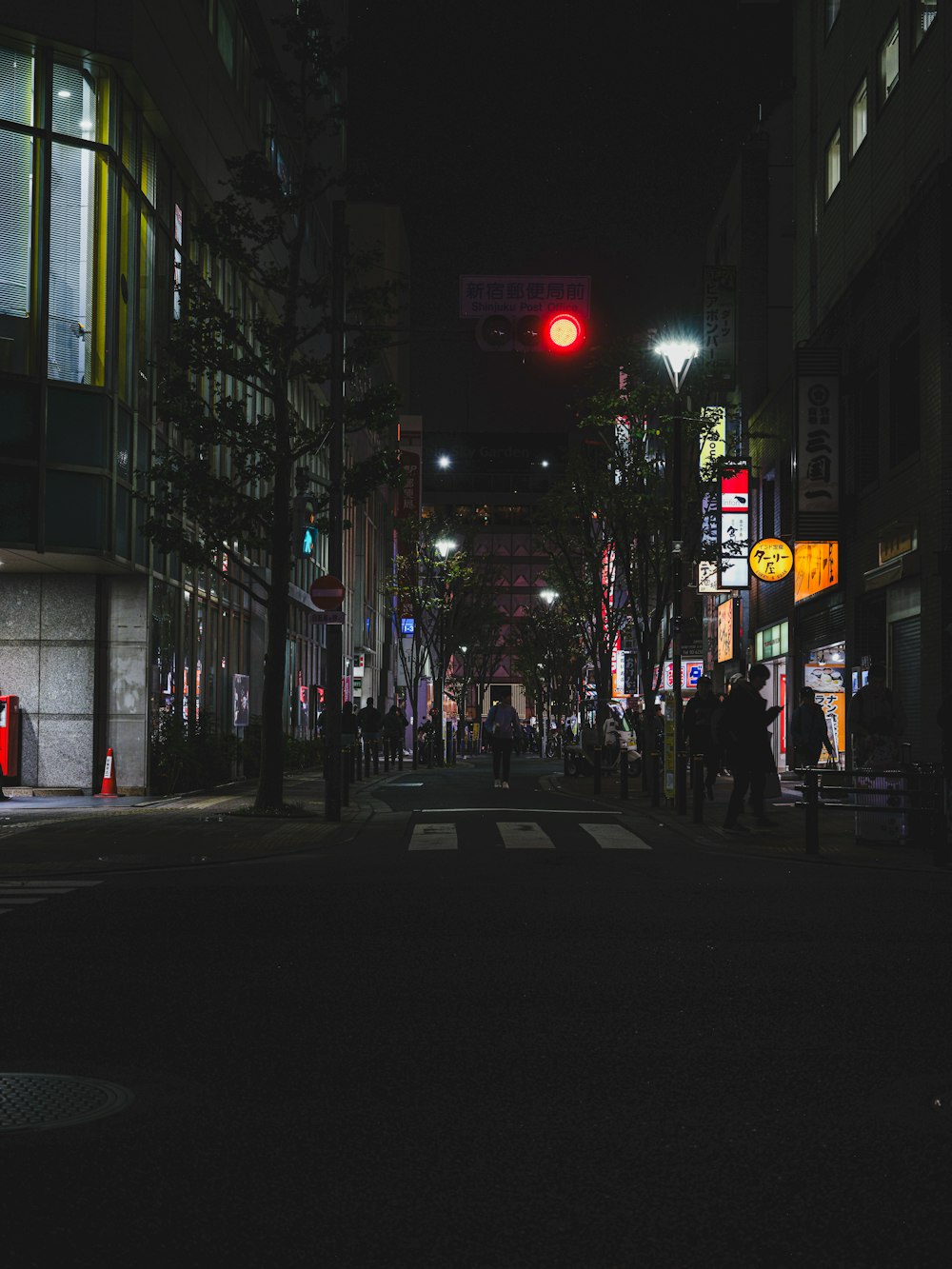 una strada cittadina di notte con un semaforo rosso