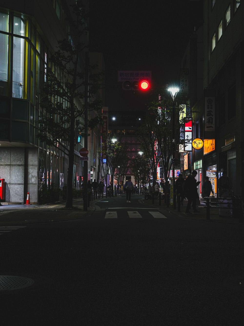 une rue de la ville la nuit avec un feu rouge