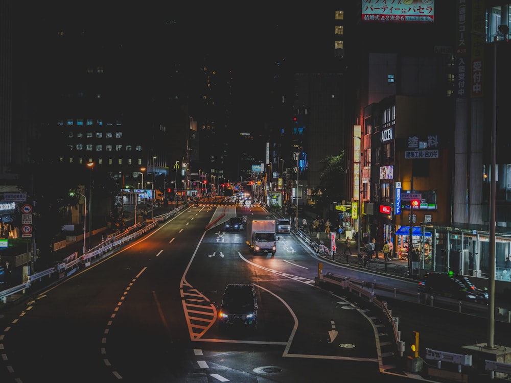 a busy city street at night with a bus driving down the street