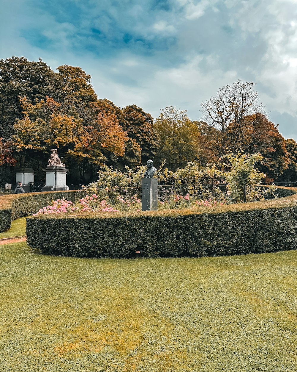 a garden with a statue in the middle of it