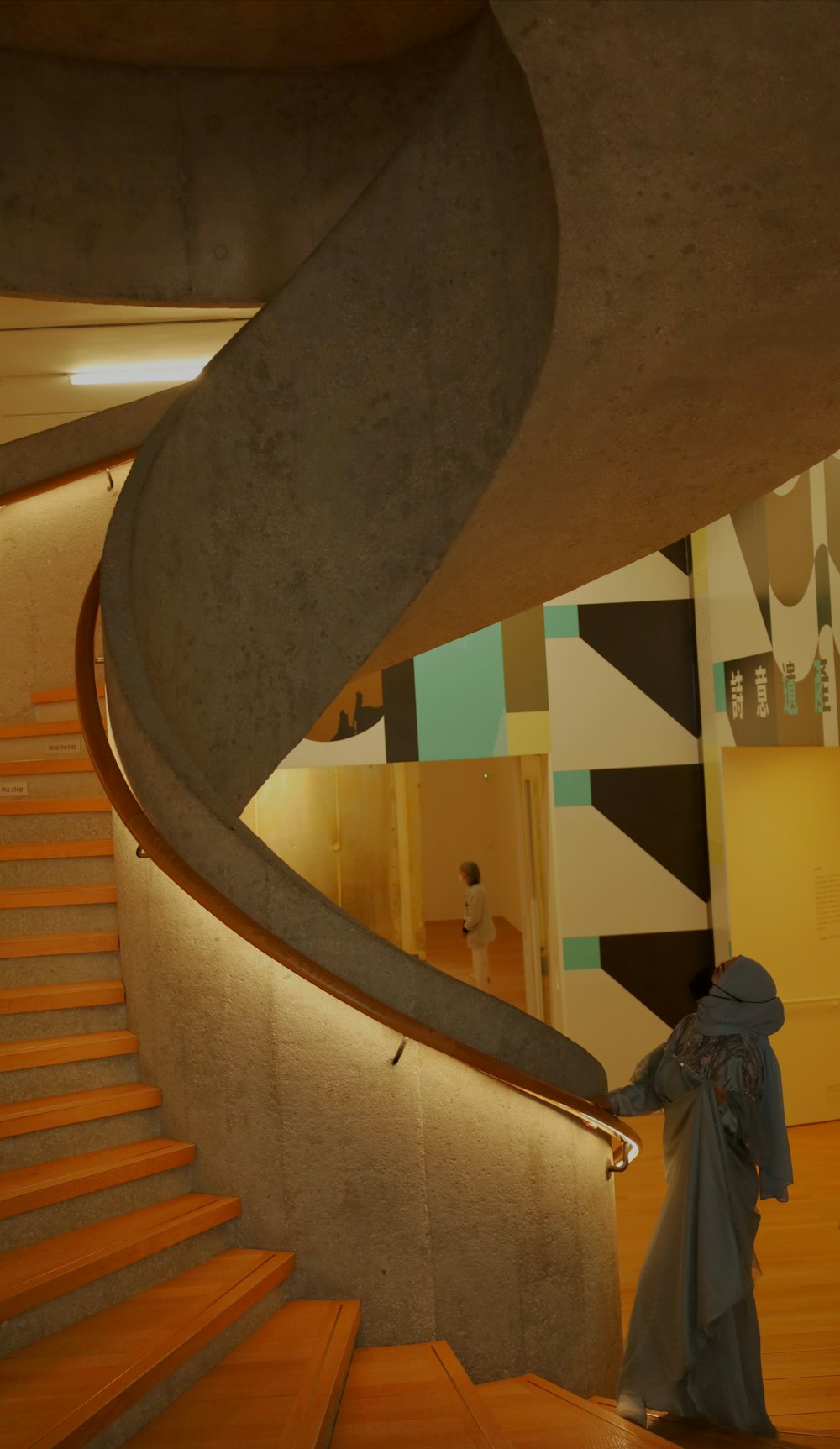 a woman in a blue dress is walking up a set of stairs