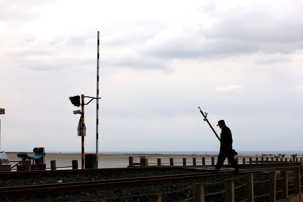 a man standing on a train track next to the ocean