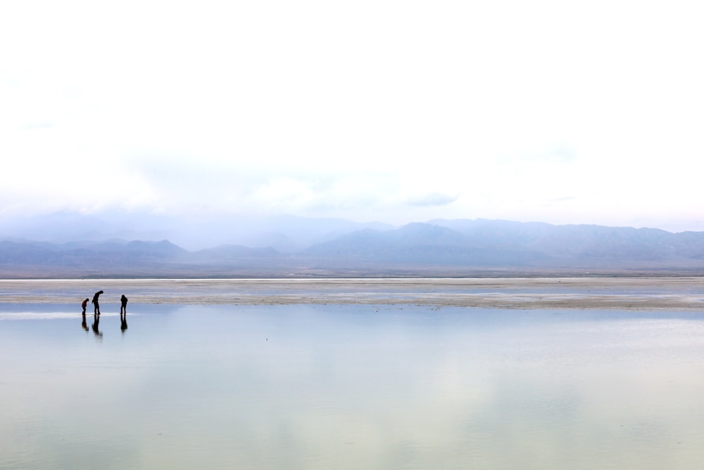 two people standing in the middle of a large body of water