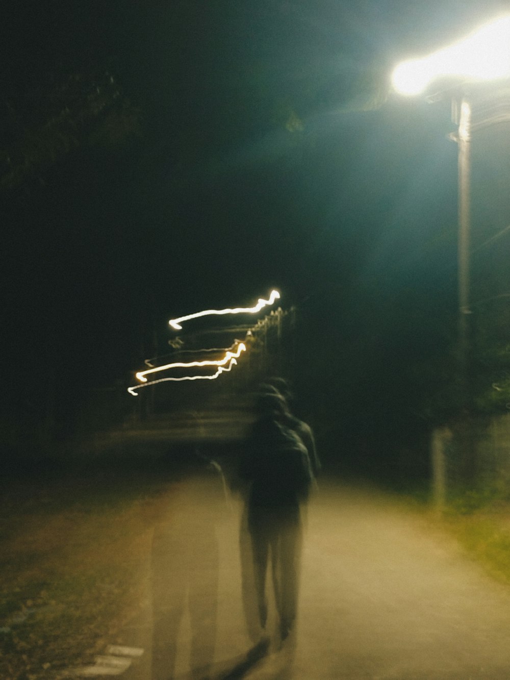two people walking down a road at night