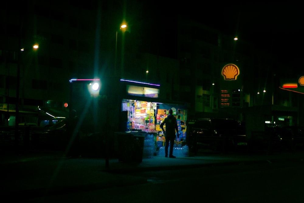 a man standing on a street corner at night