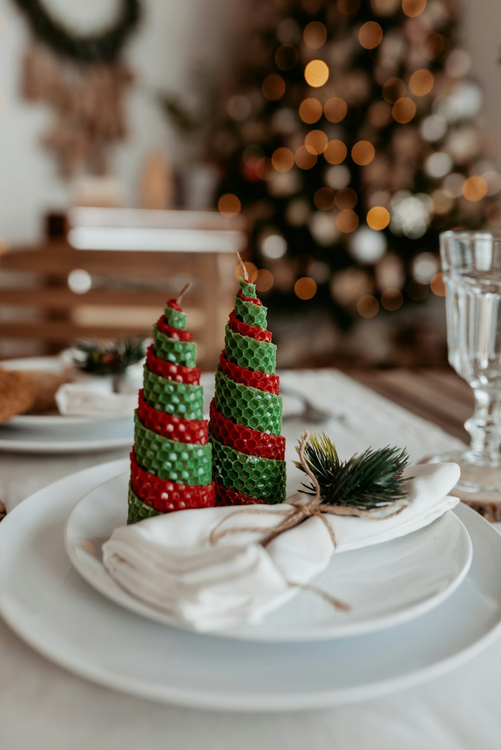 a table set for christmas with a christmas tree in the background